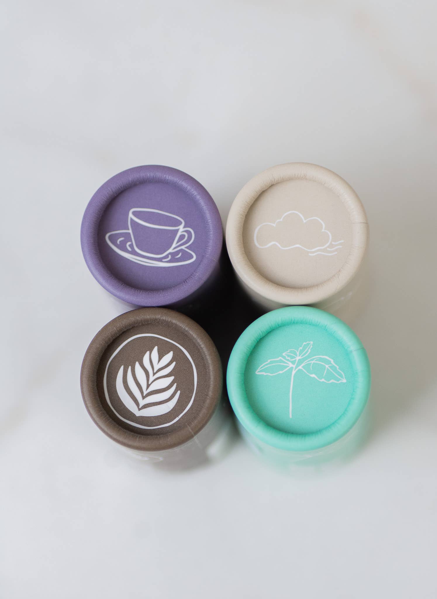 Four cylindrical containers with decorative lids on a white background