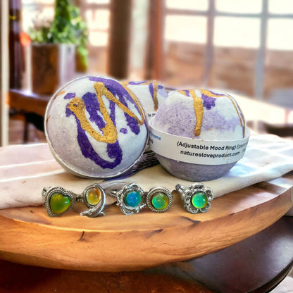 Bath bombs with decorative elements  of purple and gold, and mood rings on a wooden surface.