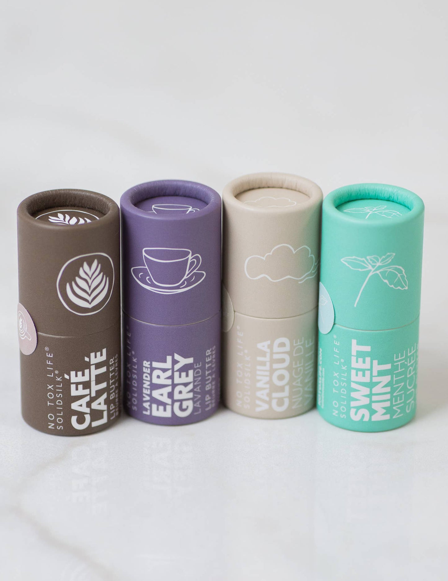 Four cylindrical containers with different flavors on a white background