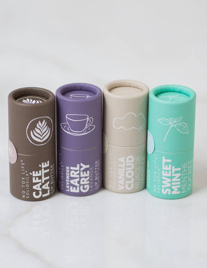 Four cylindrical containers with different flavors on a white background