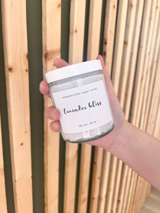 Hand holding a container labeled 'Lavender Bliss' against a wooden background