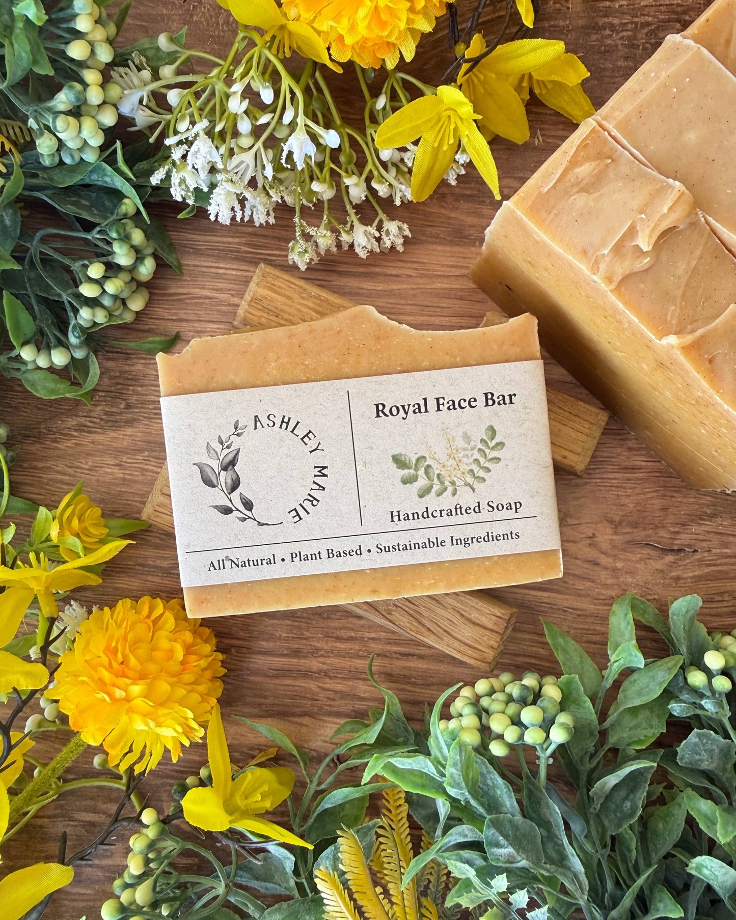 Handcrafted soap bar with a label on a wooden surface surrounded by flowers