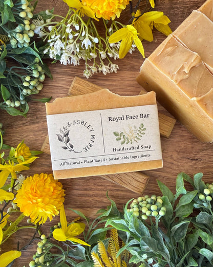 Handcrafted soap bar with a label on a wooden surface surrounded by flowers
