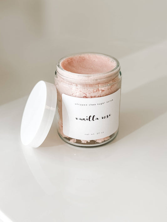 Jar of pink sugar scrub with a white label that read "Vanilla Rose" on a light background
